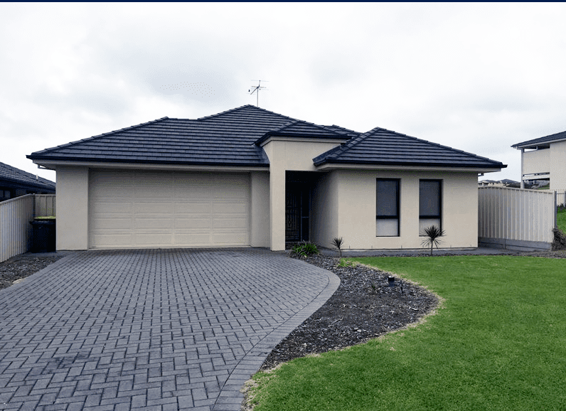 Front view of a modern residential property with a double garage, neatly landscaped front yard, and driveway.