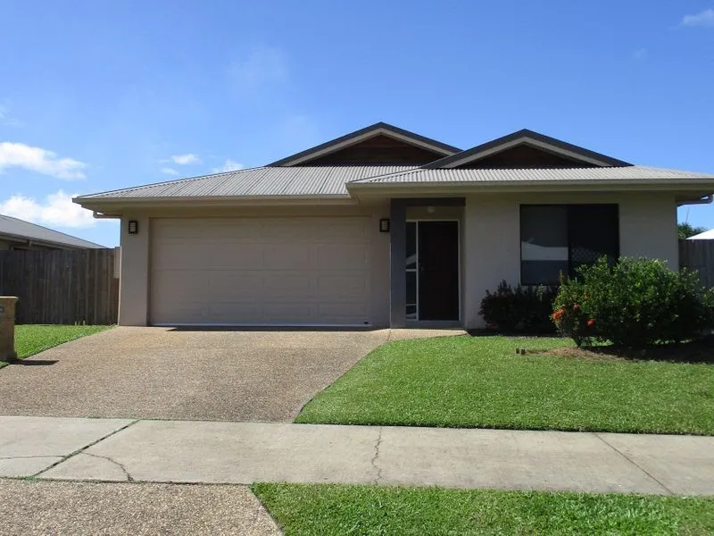 A modern single-story house with a large fenced yard, a swimming pool, and scenic mountain views in the background.