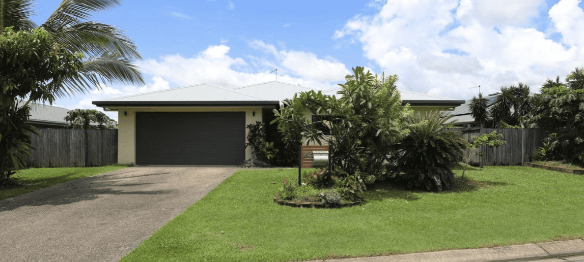 ront view of a low-set 4-bedroom home in White Rock, QLD with tropical landscaping and double garage