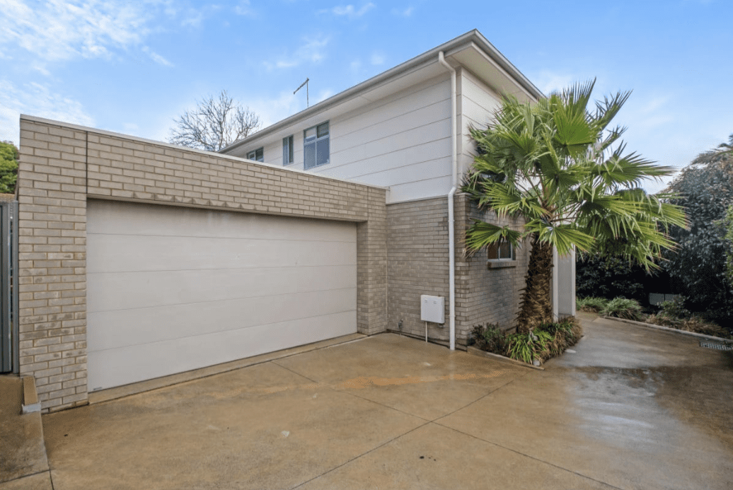 Modern two-storey brick townhouse in Christies Beach, SA with double garage and palm tree landscaping