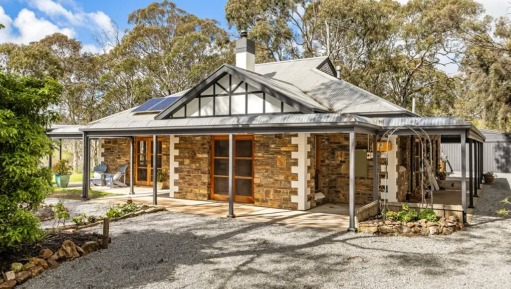 Character stone home in Macclesfield with wraparound verandah, pitched roof, timber doors and mature trees surrounding the property.