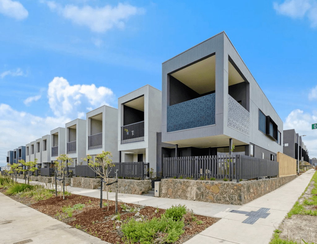 Modern two-storey townhouses with recessed balconies, stone retaining walls and contemporary facades along Orinoco Walk in Cranbourne West, Vic 3977