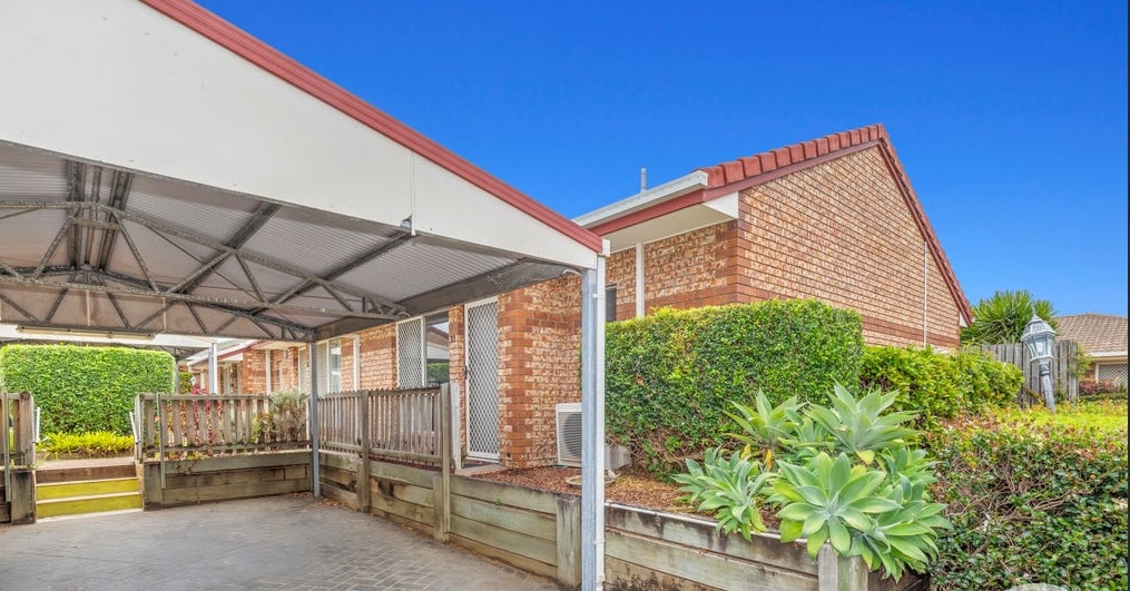 Low-maintenance brick unit with covered carport and private courtyard in a residential complex.