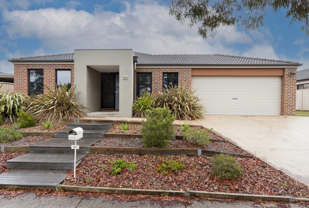 Modern single-storey brick home with landscaped front yard, double garage and contemporary façade in a suburban estate.