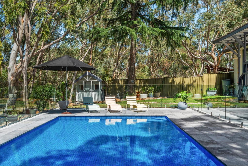 Heated swimming pool with glass fencing, cubby house and established gum trees — family entertainer home secured by 28th Street Agency, Blackwood SA